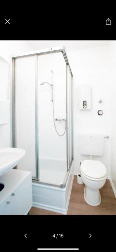 a white bathroom with a shower and a toilet at Fewo Lena in Stryck