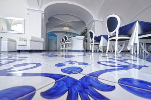 a room with a blue and white floor with chairs and tables at Hotel Villa Maria Pia in Praiano
