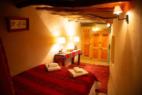 a bedroom with a bed with two towels on it at Dar Les Dattiers in Taroudant