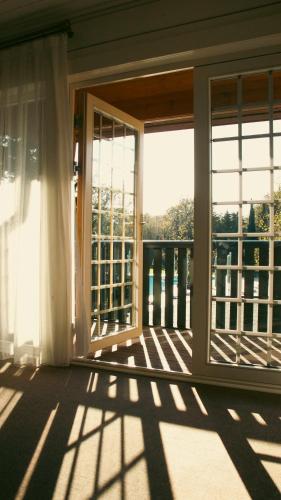 an empty room with a window and a balcony at RIVER INN RESORT AND SPA in Nabran
