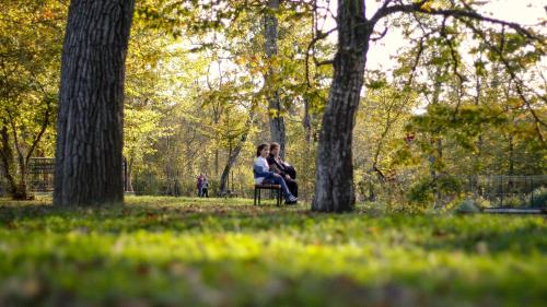 two people sitting on a bench in a park at RIVER INN RESORT AND SPA in Nabran