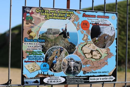 a sign in front of a fence with a map at Les Gîtes de Fabie - Villa vue mer avec spa - Plougonvelin in Plougonvelin