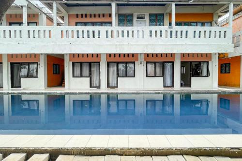 a building with a pool in front of it at Salsabila Villa Syariah RedPartner in Kedemangan-wetan