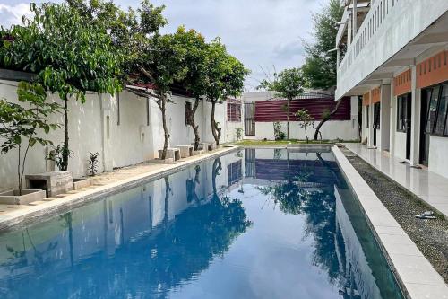 a swimming pool in front of a building at Salsabila Villa Syariah RedPartner in Kedemangan-wetan