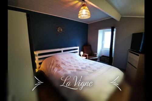 a bedroom with a bed and a blue wall at La Roche Blanche, maison de bourg pleine de charme in La Roche-Blanche