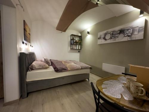 ein kleines Schlafzimmer mit einem Bett und einem Tisch in der Unterkunft Apartments Adamas in Celje
