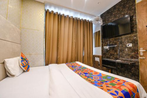 a hotel room with a bed and a television at FabHotel The Dreams in Chandīgarh