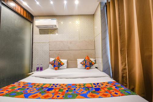 um pequeno quarto com uma cama com uma colcha colorida em FabHotel The Dreams em Chandīgarh