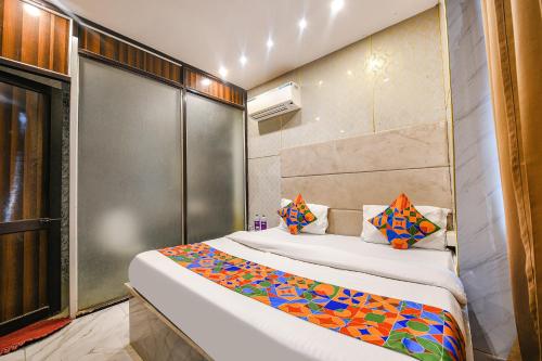 um quarto de hotel com uma cama com almofadas coloridas em FabHotel The Dreams em Chandīgarh
