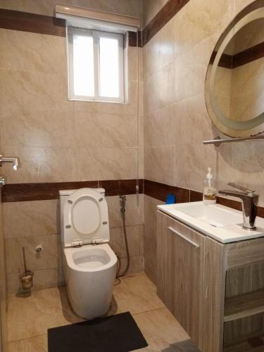 a bathroom with a toilet and a sink and a mirror at Victoria Bay in Lagos