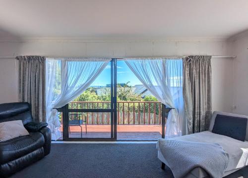 a bedroom with a bed and a view of a balcony at Available Now! Family home near Redwood Forest in Rotorua