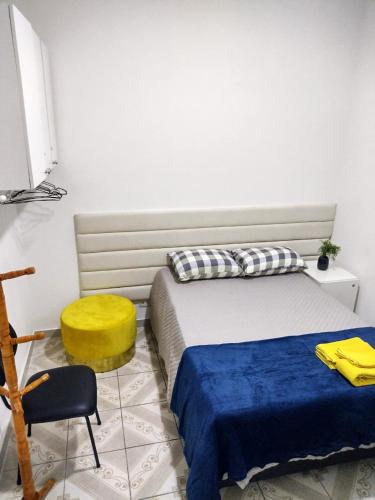 um quarto com 2 camas e uma cadeira amarela em Flat Duplo para sua conexão em Guarulhos