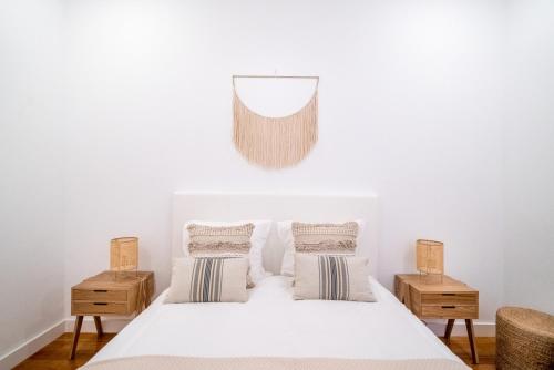 una camera con un letto bianco con due comodini di PedrasNegras30 Lisbon Lofts & Apartments a Lisbona
