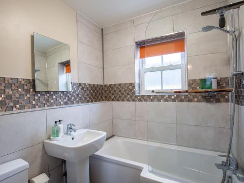 a bathroom with a sink and a tub and a shower at Bumble Cottage in Chipping Campden