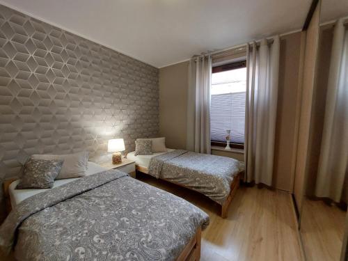 シュチェチンにあるSAS Apartamenty Green Parkのベッド2台と窓が備わるホテルルームです。