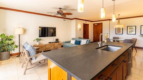 a kitchen with a sink and a living room at Ko Olina Beach Villas B403 in Kapolei