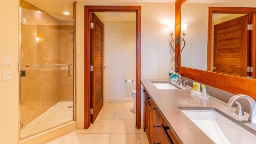 uma casa de banho com 2 lavatórios e um chuveiro em Ko Olina Beach Villas B403 em Kapolei