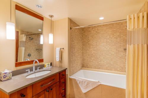 a bathroom with a tub and a sink at Ko Olina Beach Villas B403 in Kapolei