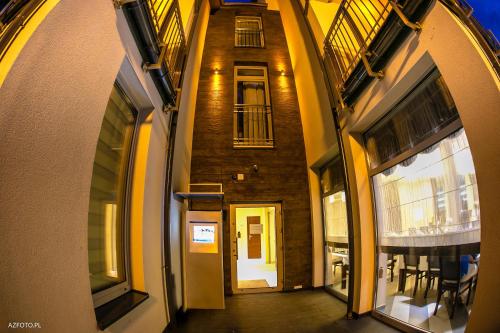 an empty hallway with a brick building with windows at Pensjonat & Spa Raj in Rajgród