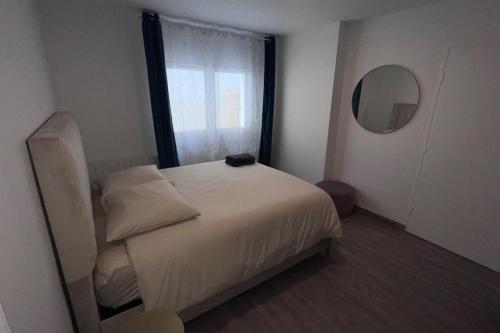 um pequeno quarto com uma cama e uma janela em Bondy11 - Gare Paris Disney em Bondy