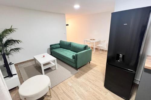 ein Wohnzimmer mit einem grünen Sofa und einem Tisch in der Unterkunft Bondy16 Gare Paris Disney in Bondy