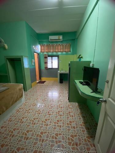 a room with green walls and a bathroom with a sink at นานา อพาร์ทเม้นท์ นราธิวาส in Kampong Botong