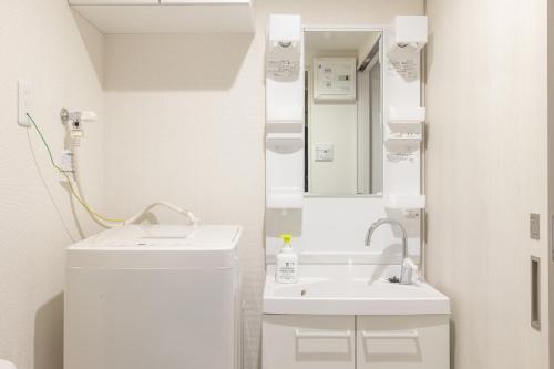 a white bathroom with two sinks and a mirror at Float Inn Asakusa in Tokyo