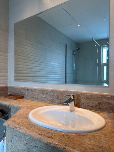 - Baño con lavabo y espejo grande en MIRADOR HOTEL, en Manama