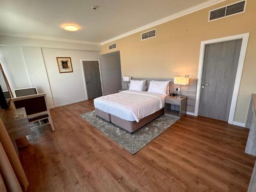 MIRADOR HOTEL في المنامة: غرفة نوم كبيرة مع سرير وأرضية خشبية