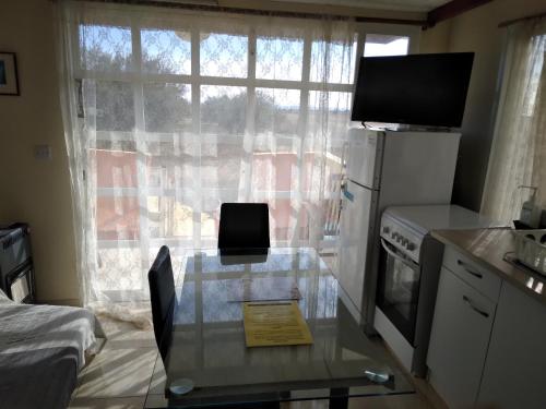a small kitchen with a glass table and a window at MERSINERA Paradise Garden NOAH HOUSE in Kivisil