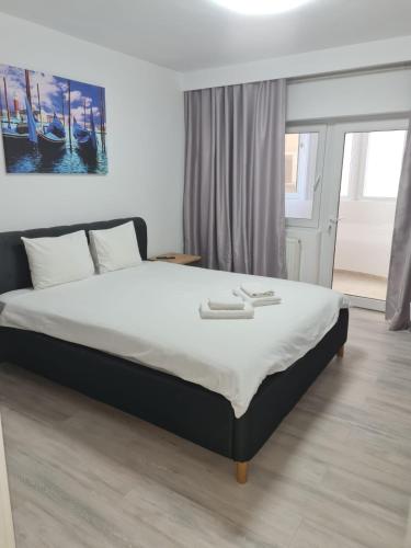 a bedroom with a large bed with white sheets at Seaview Residence in Constanţa
