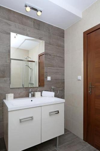 a bathroom with a white sink and a mirror at Welcome to Island Krk! in Linardići