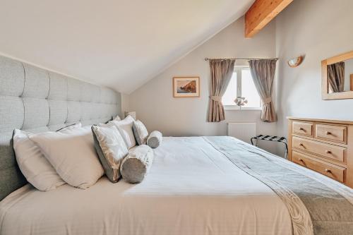 a bedroom with a large bed with white pillows at Swallow Lodge with Hot Tub, dogs welcome sleeps 8, Great resort Facilities in Padstow