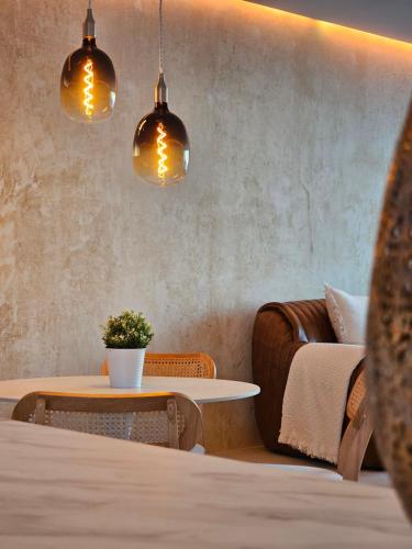 a living room with a table and two pendant lights at Stylische Sunset-Wohnung in Augsburg