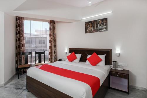 a bedroom with a large bed with red pillows at OYO Hotel Lotus Prime in Jaipur
