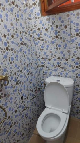 ein Bad mit einem weißen WC in einem Zimmer in der Unterkunft Sawadogo meublée in Ouagadougou