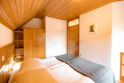 a bedroom with a bed with a wooden ceiling at Govc-Vršnik in Solčava