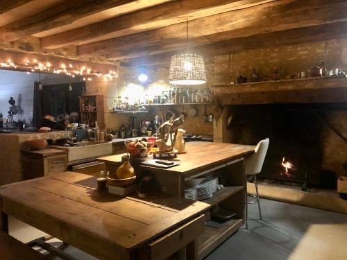 cocina con mesa de madera y chimenea en la meyrolette, en Mauzens-et-Miremont