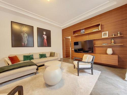 un salon avec un canapé et une télévision dans l'établissement Nestor&Jeeves - VICTOIRE - Central - Near Beach, à Nice