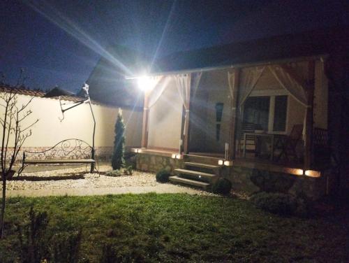 a house with a bench in the yard at night at Magnólia Vendégház in Villány