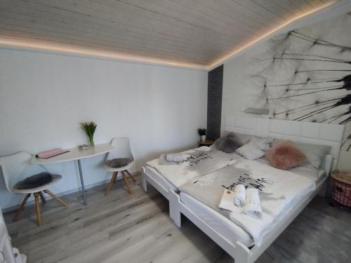 a bedroom with a bed and a desk and a table at Magnólia Vendégház in Villány