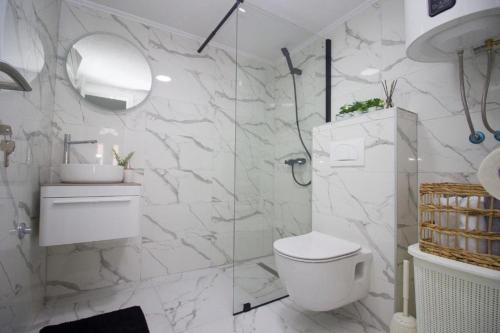 a white bathroom with a toilet and a glass shower at Summer House with Heated Swimming Pool in Mostar