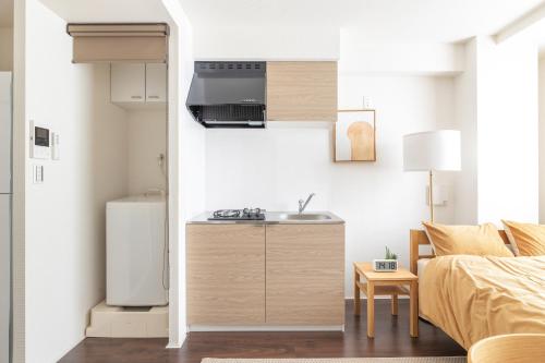 a small kitchen with a sink and a refrigerator at Float Inn Asakusa in Tokyo
