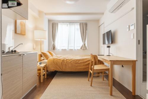 a bedroom with a bed and a desk and a table at Float Inn Asakusa in Tokyo