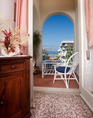 a room with a balcony with a table and a chair at My Home Hotel in Bellaria-Igea Marina