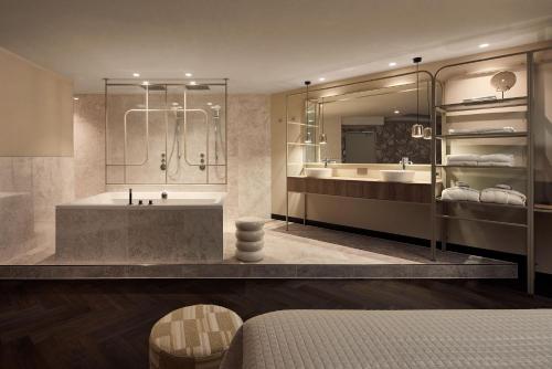 a bathroom with a tub and two sinks and a shower at Van der Valk Hotel Groningen Zuidbroek in Zuidbroek