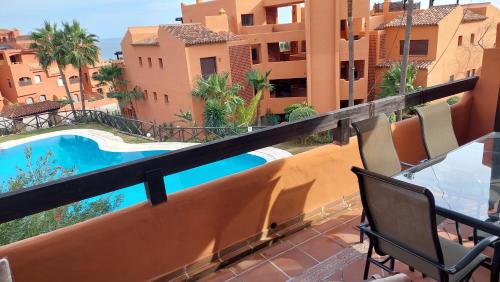 a balcony with a view of a pool and buildings at Jardines, piscina y mar in Estepona