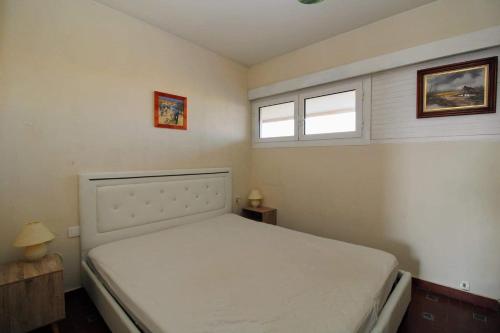 - une chambre avec un lit blanc et 2 fenêtres dans l'établissement Splendide Vue sur le port St Cyp, à Saint-Cyprien