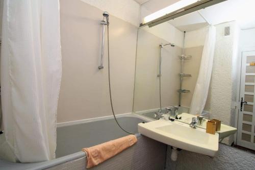 La salle de bains est pourvue d'un lavabo et d'une baignoire avec douche. dans l'établissement Splendide Vue sur le port St Cyp, à Saint-Cyprien