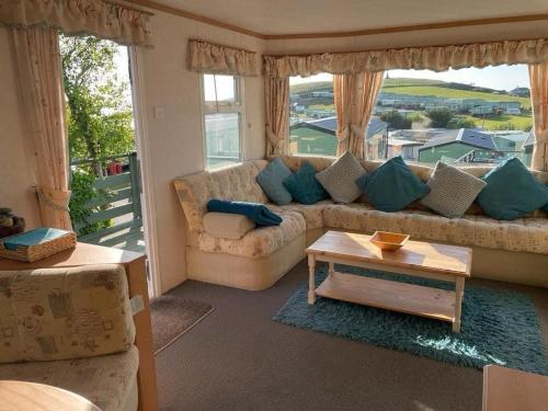 a living room with a couch and a table at 2 bedroom cosy caravan in Borth